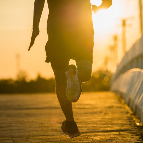 silhouette of a young fitness man running on sunrise